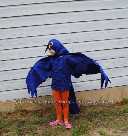 Este es un disfraz de loro guacamayo azul hecho a mano por (yo) una madre ama de casa y un artista independiente.  Este disfraz se basa en una capa de camiseta azul.