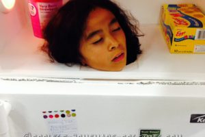 Disfraz de refrigerador realista con una cabeza congelada en el interior.