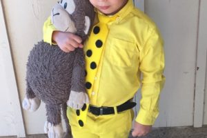 Hombre disfrazado de niño con sombrero amarillo